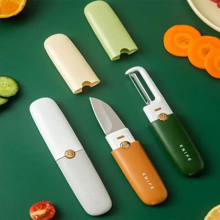 Compact kitchen knife and peeler set with protective covers on green surface surrounded by vegetable slices
