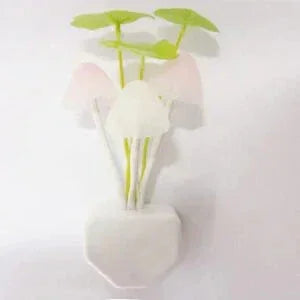 Artificial lotus plant with green and white leaves in a white pot on white background