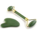 green jade roller and gua sha stone facial massage tools with gold accents on white background
